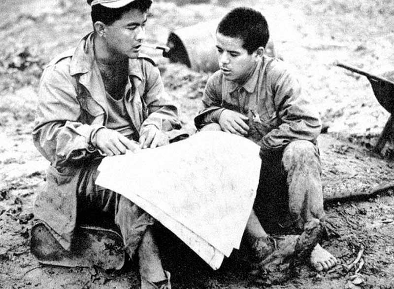 Technical Sergeant (TSgt) Warren T. Higa, 314th Headquarters Intelligence Detachment non-commissioned officer-in-charge (NCIOC), interrogates a Japanese prisoner on Okinawa.