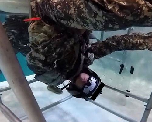 A 160th SOAR aviator candidate releases his seat straps during dunker training at the Allison Aquatics Training Facility, Fort Campbell, KY.