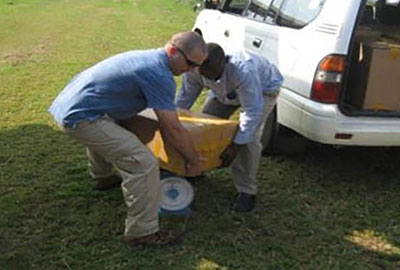 SGT Pete H. Blackman* (left) and an Invisible Children representative transfer boxes of leaflets from a van to a Cessna 208 on 6 July 2012.