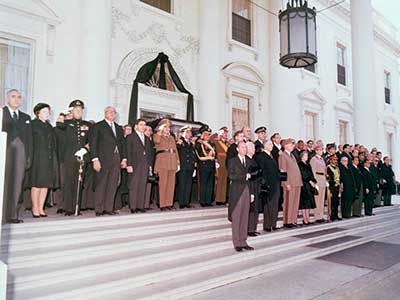 Dignitaries representing nearly 100 countries stand outside the White House, where the caisson made a brief stop en route from the Capitol Building to St. Matthew's Cathedral around noon on Monday, 25 November.