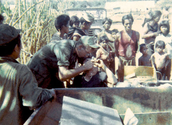 SP5 Jerry Bisco of Team 15 provides dental care for villagers near Pleiku. 