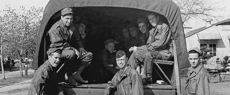 MSG Frank S. Zablocki (left, standing), 2LT Robert M. Zweck (center, standing), and a group of enlisted men.