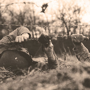 Two Second Army Ranger School instructors demonstrate barbed wire cutting with cloth-wrapped clippers.