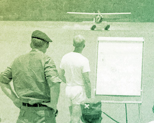 3/5th SFG personnel with RB-10 rubber boats beached watch the landing of the U-10A Super Courier float plane.