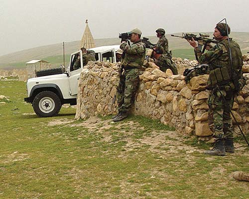 Special Forces team personnel observe the village of Ayn Sifni from the high ground to the north.