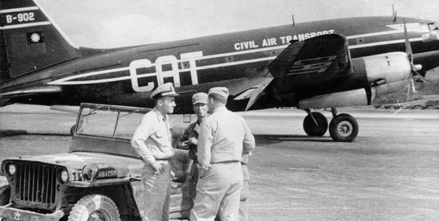 Civil Air Transport Curtiss C-46 Commando aircraft with JACK Navy Lieutenant George Atcheson, Korean Captain Han Chul-min, and Marine Major Vincent A. &ldquo;Dutch&rdquo; Kramer standing by their jeep.