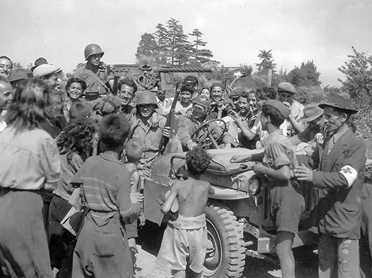 Radcliffe’s patrol is greeted by cheering Romans. Radcliffe is the soldier in the passenger’s seat of the jeep.