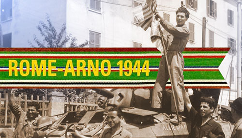 Standing aside the turret of this M-8 armored car, a member of Radcliffe's patrol raises the flags of the United States and Canada so that they may be documented by the accompanying photographers. 