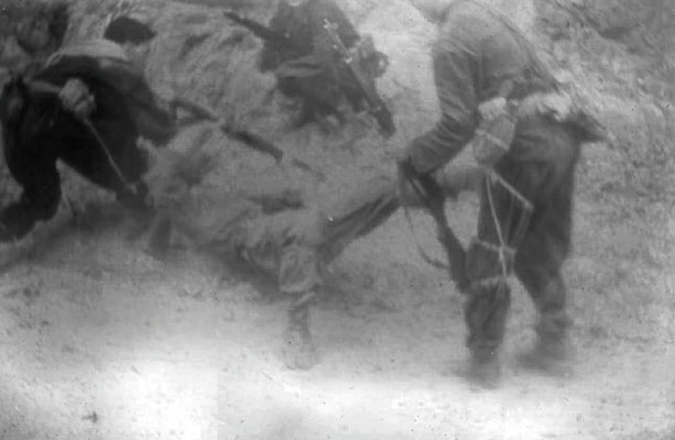 A Colombian Lancero is physically taken captive by aggressors from Batallón Colombia.