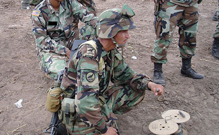 After preparing and setting the charges, an SF sergeant oversees a Colombian soldier as they prepare to detonate the explosives.