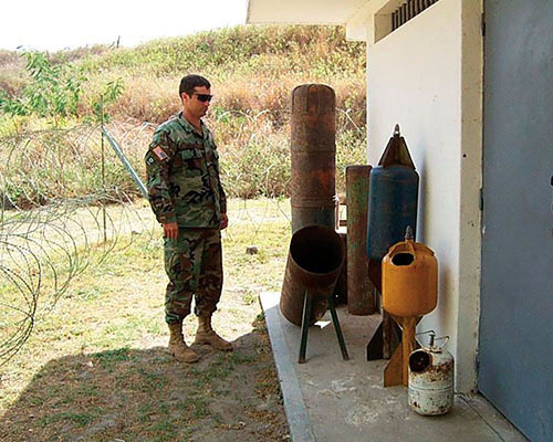 Captain Steve McAdam*, team leader of ODA 741, with “barbecue bombs” made from propane cylinders.