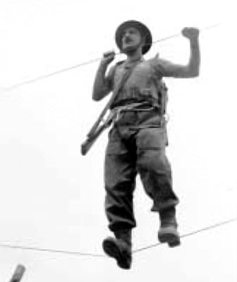 An SOE trainee crossing a two-rope bridge at STS 25.