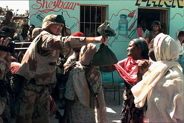 CA soldier distributing humanitarian relief supplies.