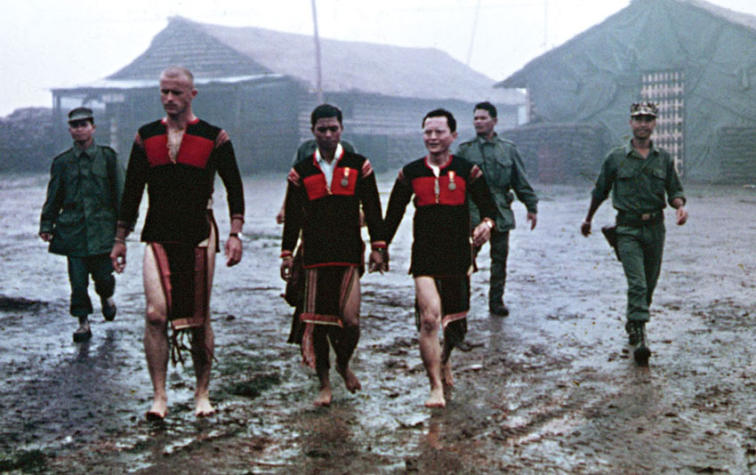 Captain Vernon Gillespie, Y Jhon, and Captain Truong walk through the camp together to the sacrifice ceremony.