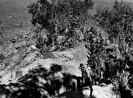 C-47 cargo aircraft flying below the MARSmen shows how the term “hills” was an understatement in Burma.