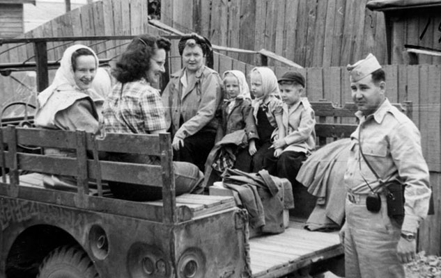 101st Military Government Group families enroute to a picnic in the &ldquo;family car&rdquo; in Chonju, 1947. Mrs. Mary Vangen, Mrs. Novotney, Mrs. Curtis, two Vangen daughters in scarves (Sheryl and Sharon), unknown boy, and 1LT Novotney.