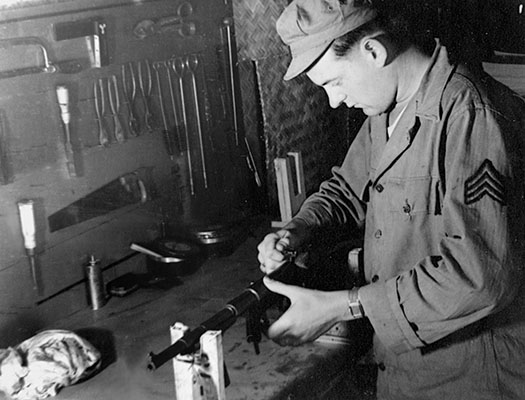 Sergeant Harold “Bud” Banker works on a United Defense UD-42 or “Marlin” submachinegun at the Detachment 101 supply depot at Nazira, India.