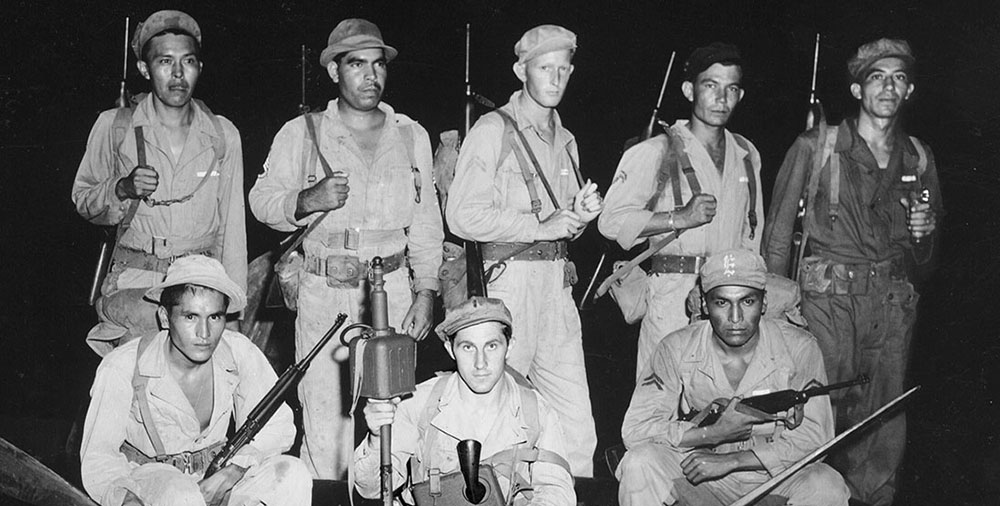 A Scout team at the 1st ASTC prepares to conduct a night reconnaissance. Front L-R, PFC Joseph Johnson, 1LT Michael Sombar and CPL David Milda. Back L-R, SGT Byron Tsingine, SSG Alvin Vilcan, CPL John A. Roberts, CPL Walter A. MacDonald and SSG Caesar Ramirez, 8 January 1944.