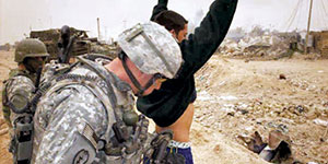 Concerned that the first enemy fighter to surrender is a suicide bomber, he is thoroughly searched by C Company personnel.