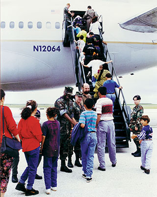 The first groups of Kurds leave Guam after getting clearance to emigrate to the United States. Kneeling, partly obscured is the JTF-PH commander, MG Dallager, standing is Rear Admiral Brewer, the deputy commander, and then the lone Army representative, CPT Richard Sele, from the  321st Civil Affairs Brigade.