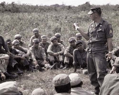 SFC Ethyl W. Duffield explains the 60 mm mortar to the Bolivians.