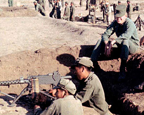 SGT Alvin E. Graham(r) training Bolivian infantrymen on the Browning M-1919A6 .30 caliber light machinegun. On Graham&rsquo;s right is a cameraman from a SOUTHCOM film crew. SGT Graham, SSG Wendell P. Thompson, and SGT Byron R. Sigg were all radio operators who served as assistant instructors on the firing ranges.