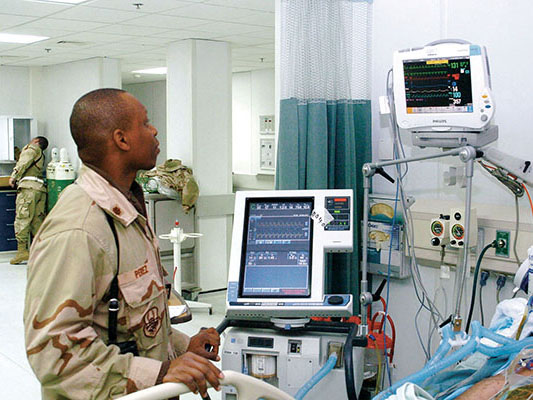 U.S. Air Force surgeon Major Clifford Perez checks a patient’s vital signs at Craig Theater Hospital in Bagram.