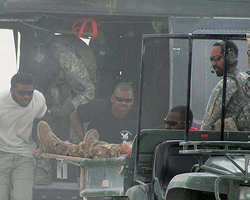 Specialist Donnell Smith, Sergeant Archer and Specialist Dwayne Bostic unload a casualty from the UH-60 MEDEVAC helicopter in Farah, Afghanistan.