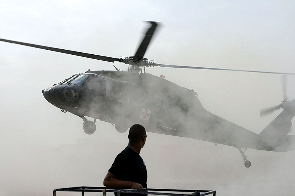 A member of the Civil Affairs team watches as the UH-60 MEDEVAC bird prepares to touch down with patients for the SORT.