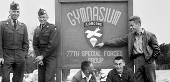 Josef and Ctirad &ldquo;Ray&rdquo; Masin and Milam Paumer with friends in front of the 77th SFG Gymnasium sign on Smoke Bomb Hill, Fort Bragg, NC.