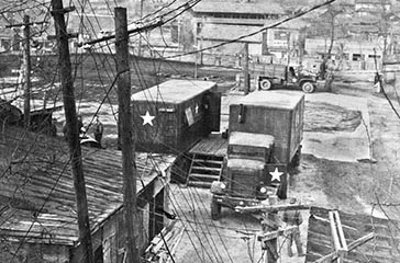 Publications Platoon photo vans with Federal G-513, 94x43 tractor, 4-5 ton, 4x4 in the corner of the motor pool.