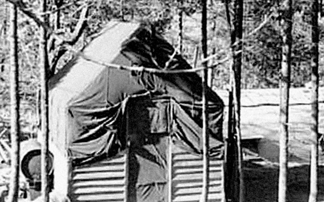 In &ldquo;Paradise Pines&rdquo; behind the Radio Pusan, the officers lived in a lone wood-framed tent. The Quonset huts where the soldiers were billeted are visible behind the tent.