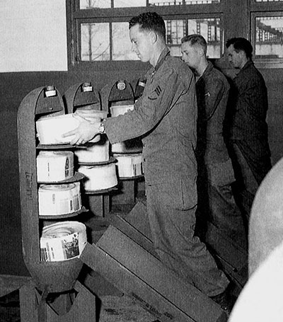 Rolled leaflets are loaded into 500 pound M16A1/2 Cluster Adapter Bombs