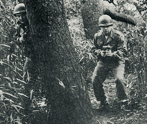 PFC Richard George, armed with an M3A1 .45 cal submachinegun “Grease Gun” kept aggressors from seizing Hama Park.