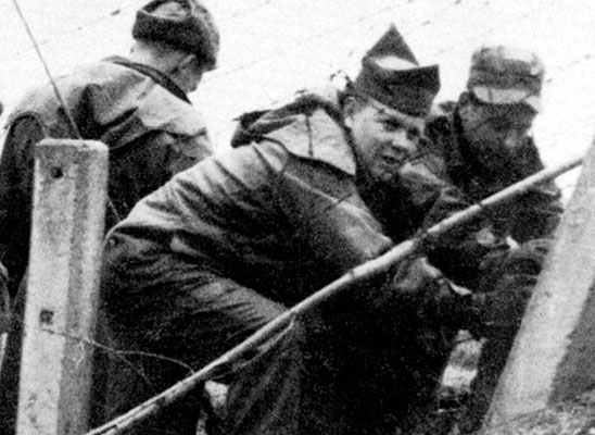 4th MRBC Rigger CPLs Bob Adams and Bill Keenan with others install fencing to prevent sabotage.