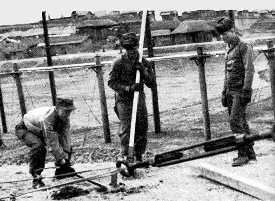 PFCs Frank Poulalion and Bob Carroll along with another rigger batten down Seoul&rsquo;s new antenna.