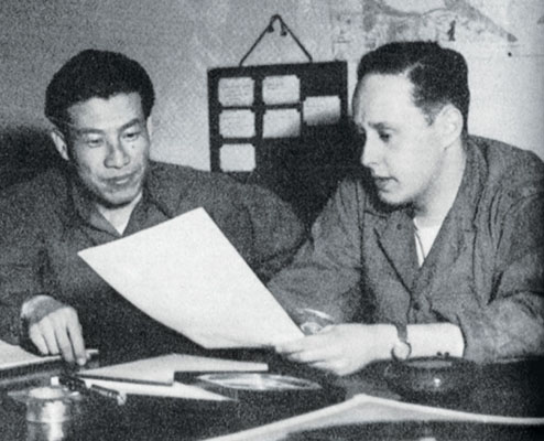 Korean translator Chang Sang Moon listens as the Radio Seoul production man, CPL Sigmund S. &ldquo;Sig&rdquo; Front, explains a broadcast.