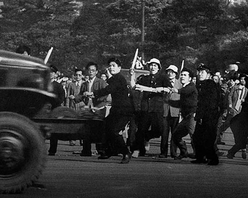 Lead Communist elements of the parade hurled a police barricade at a U.S. Army 6 x 6 truck by the Imperial Plaza.