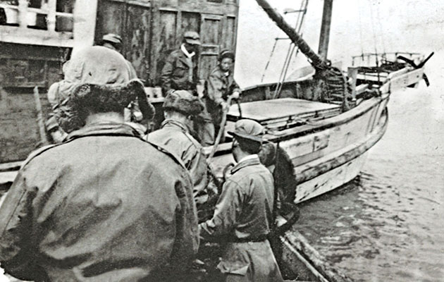 Crew manuvering a Yak into port.