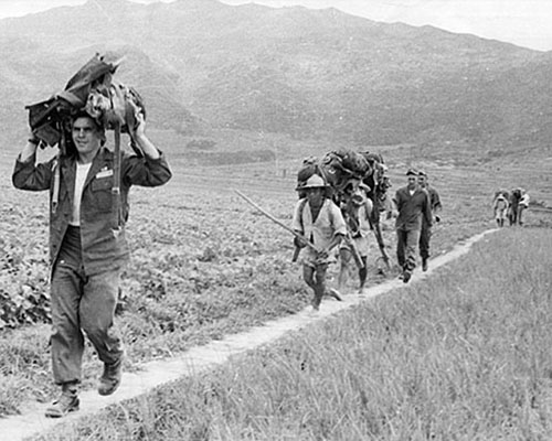 SGT Thomas G. Fosmire, JACK Maritime Ops and SGT Donald F. Stephens, JACK Air Section, return to the assembly area after making a pay jump near Pusan in 1952.