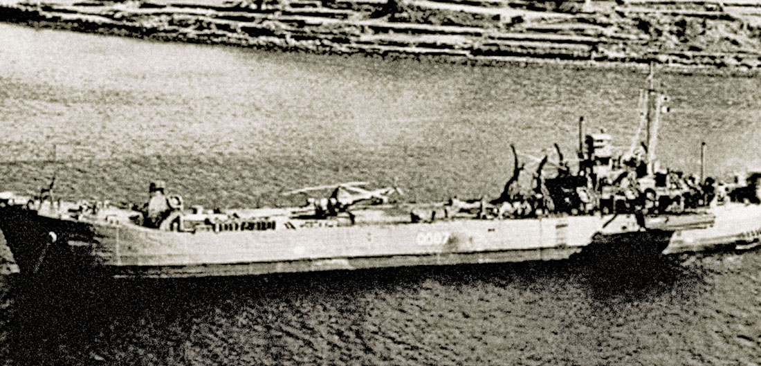 A H-5 Dragonfly helicopter belonging to HU-1 stands ready aboard the Japanese LST 0007, the back-up for U.S. Navy LST-799.