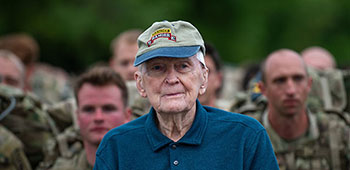 Retired U.S. Army Col. Ralph Puckett stands along side troops as they prepare to start a foot march during the 2021 David E. Grange Jr. Best Ranger Competition (BRC) on Fort Benning, Ga., April 16, 2021. The BRC is a three-day combat-focused military skills competition that challenges the physical and mental endurance of the competitor, highlighting tasks that Rangers routinely conduct in times of peace and war.