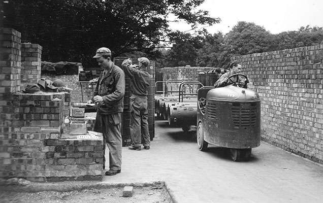 Personnel at the Area H, the SO packing station, prepare aerial delivery containers for loading.